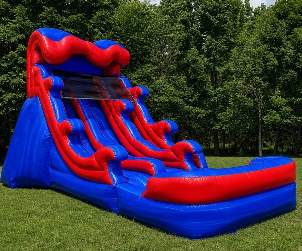 Tall red and blue inflatable water slide with a splash lane, set up on grass